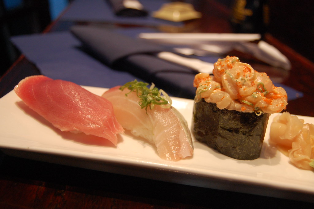Assorted nigiri sushi on a traditional wooden serving board